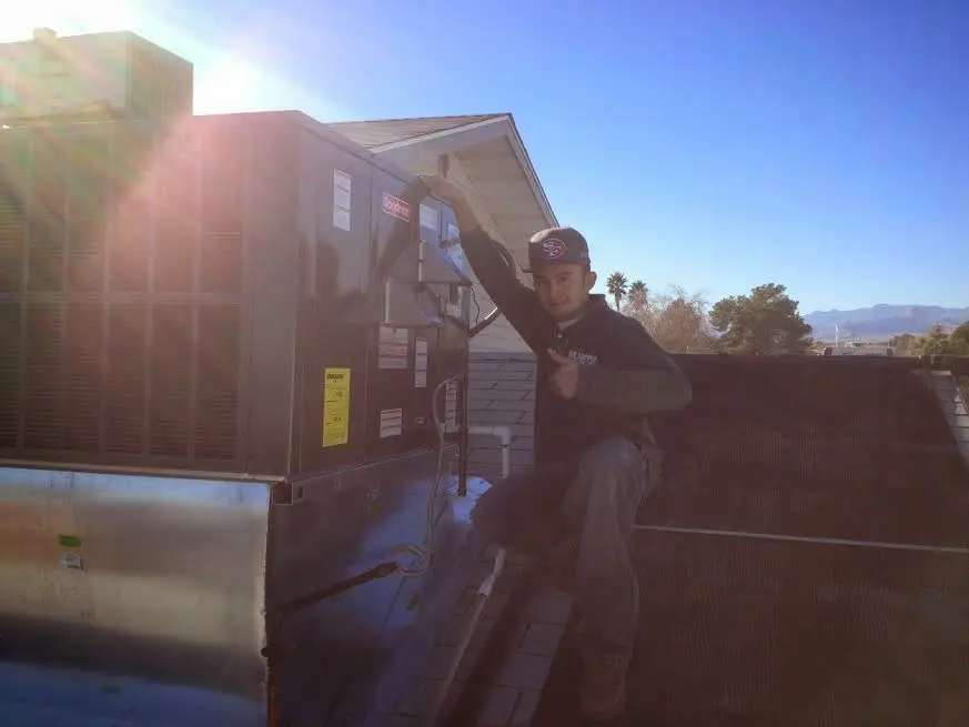 HVAC technician performing AC Tune-Up on a rooftop unit in Newfane
